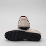 Par do modelo Mocassim Driver de Camurça Capri Tobacco, na cor branco, com um dos solados voltado para a câmera.