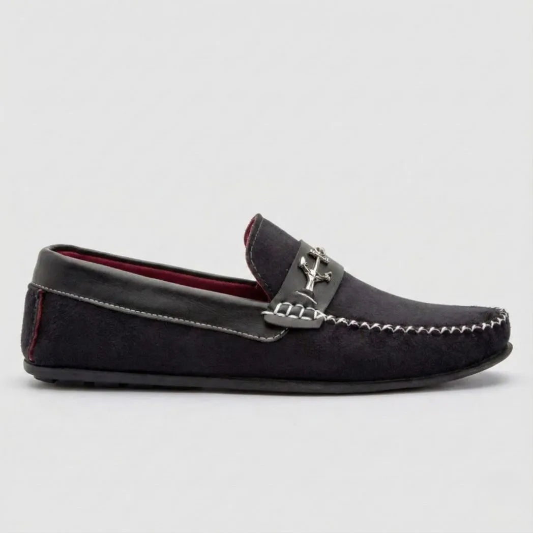 Mocassim Driver de Camurça Náutico: modelo azul-escuro de perfil, com ferragem em forma de âncora, costura clara e sola preta.