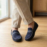 Mocassim Driver de Camurça Stripes: par azul-escuro com faixa frontal usado com calça clara dobrada na barra.