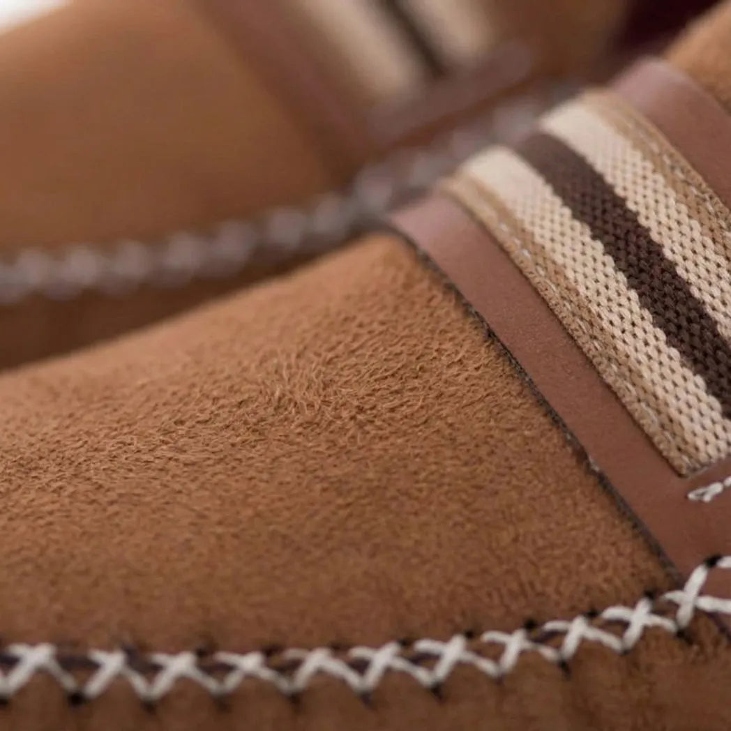 Mocassim Driver de Camurça Stripes: detalhe da textura marrom, da faixa frontal listrada e da costura clara cruzada.