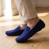 Mocassim Driver de Couro Capri Nero na cor azul, usado com calça clara de barra dobrada.