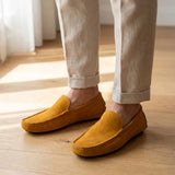 Mocassim Driver de Couro Capri Nero na cor amarelo, usado com calça clara de barra dobrada.