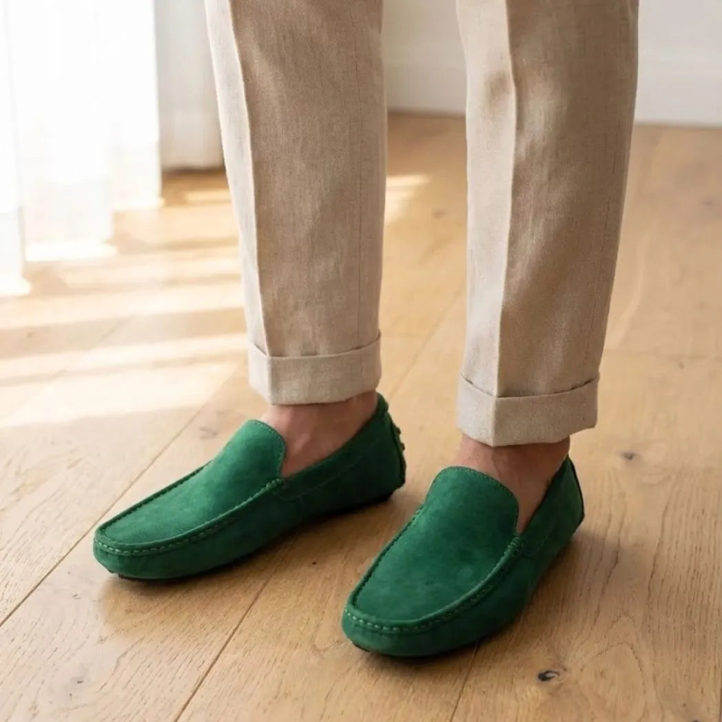 Mocassim Driver de Couro Capri Nero na cor verde, usado com calça clara de barra dobrada.