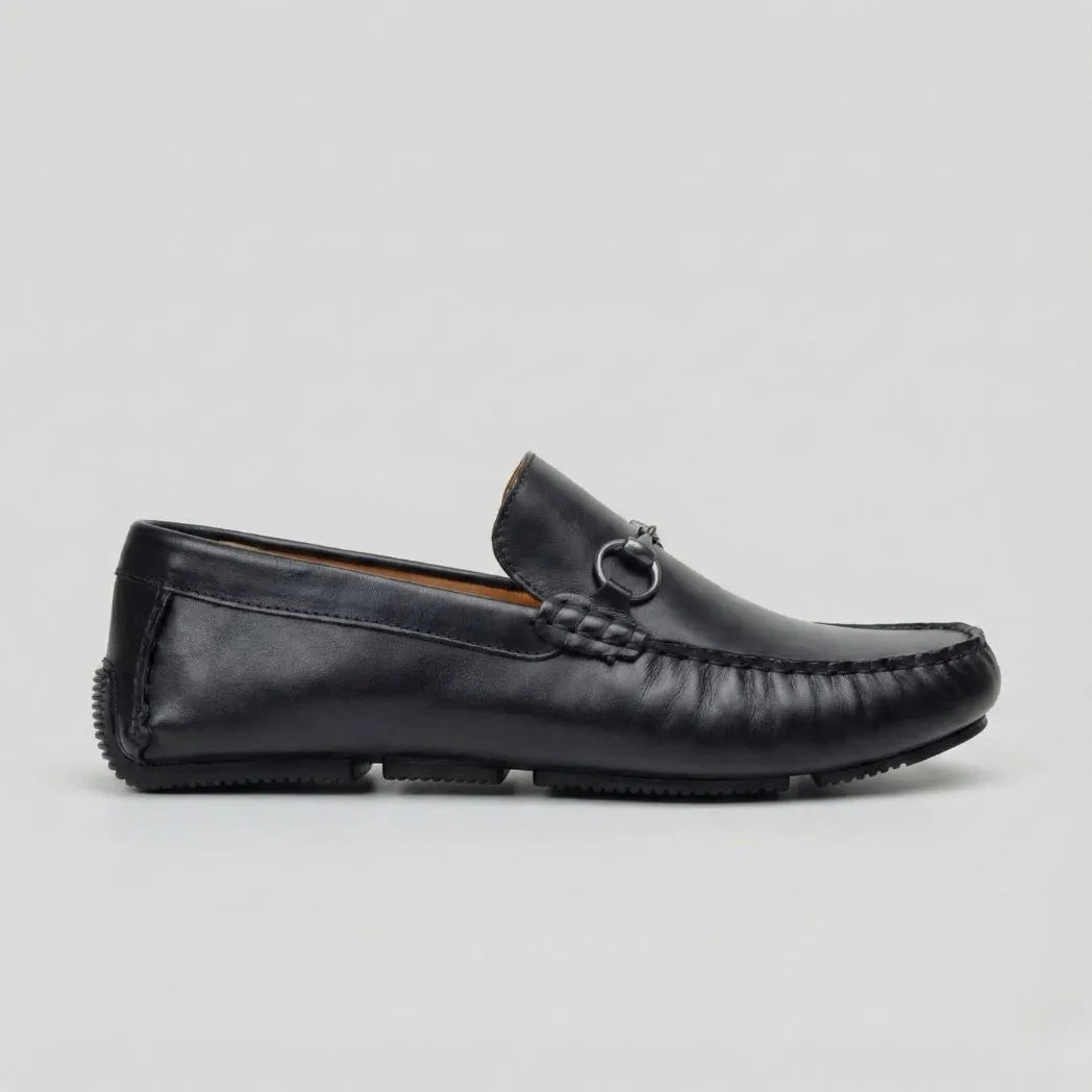 Mocassim Driver de Couro Portofino: modelo preto de perfil, com ferragem frontal em forma de argola e costura aparente.