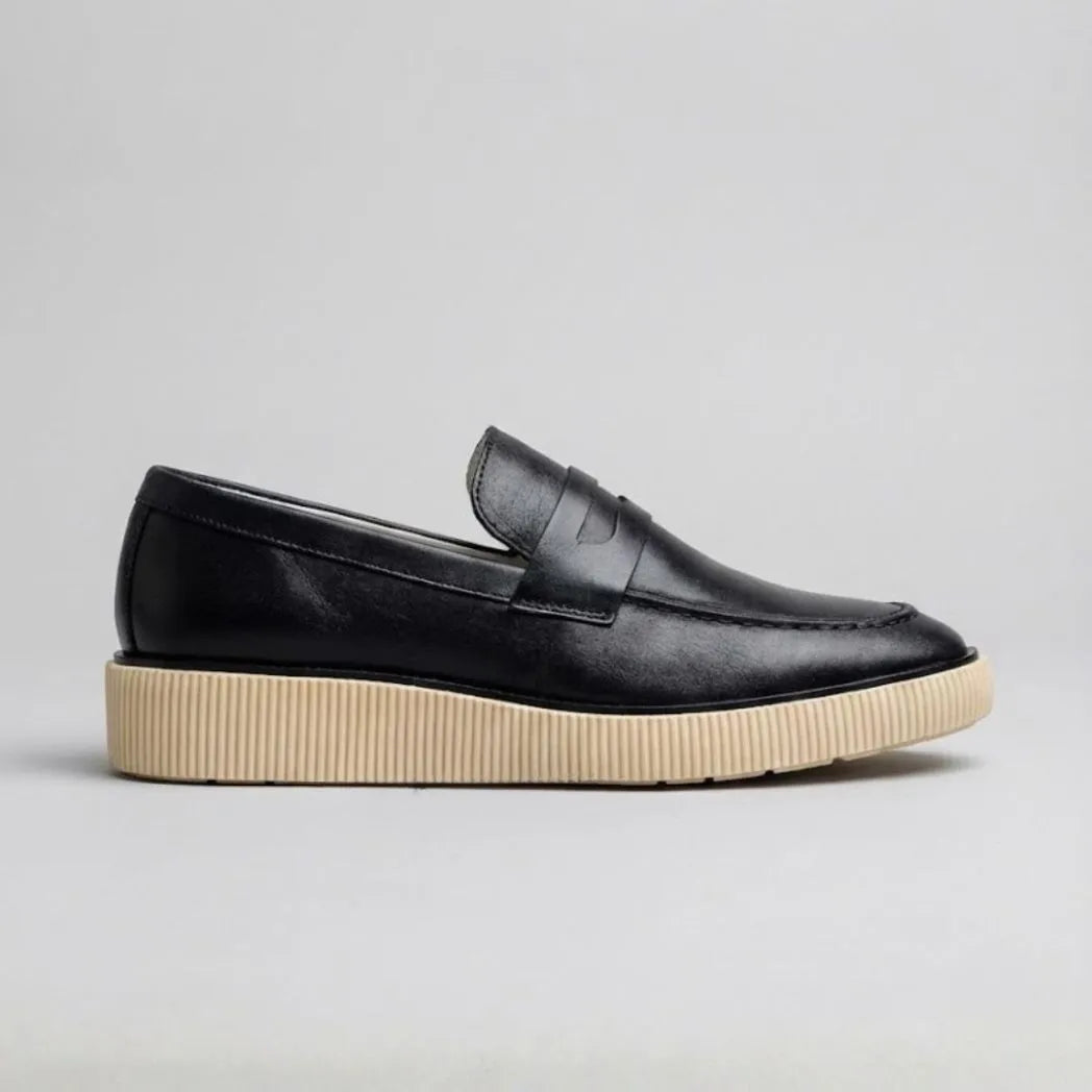 Mocassim Loafer Londres de Couro preto com solado claro canelado, em vista lateral.