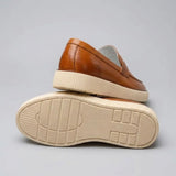 Mocassim Loafer Urban Londres de Couro: par marrom com um sapato virado, mostrando a sola bege com sulcos.