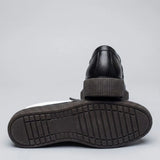 Mocassim Loafer Urban Londres de Couro: par preto com um sapato virado, mostrando a sola preta com sulcos.