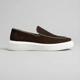 Mocassim Loafer de Camurça Vanguard: modelo marrom-escuro de perfil, com contorno da parte frontal claro e sola branca.