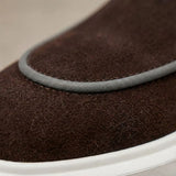 Mocassim Loafer de Camurça Vanguard: detalhe da textura marrom-escura e do contorno claro da parte frontal.