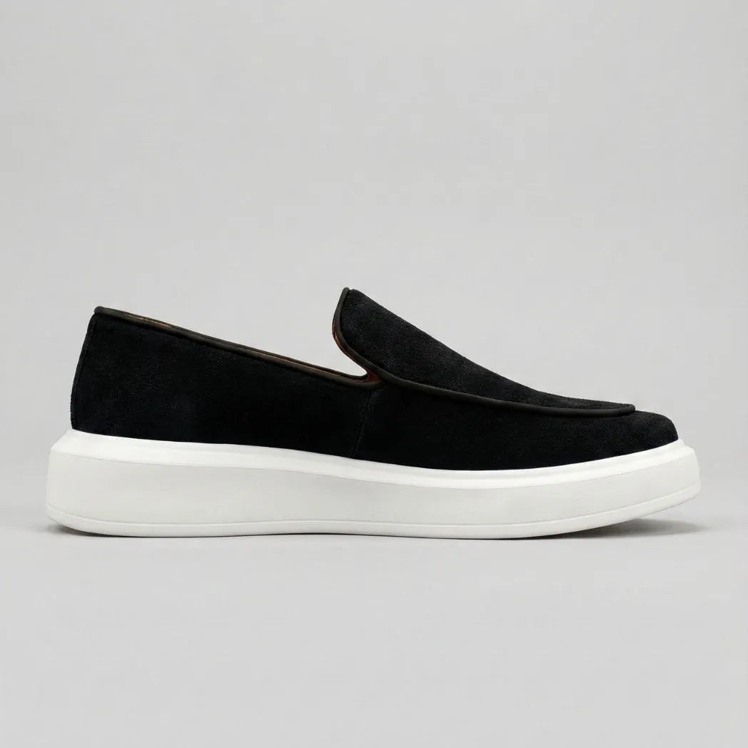 Mocassim Loafer de Camurça Vanguard: modelo preto de perfil, com sola branca.