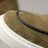 Mocassim Loafer de Camurça Vanguard: detalhe da textura verde-oliva, do contorno escuro e da borda da sola branca.