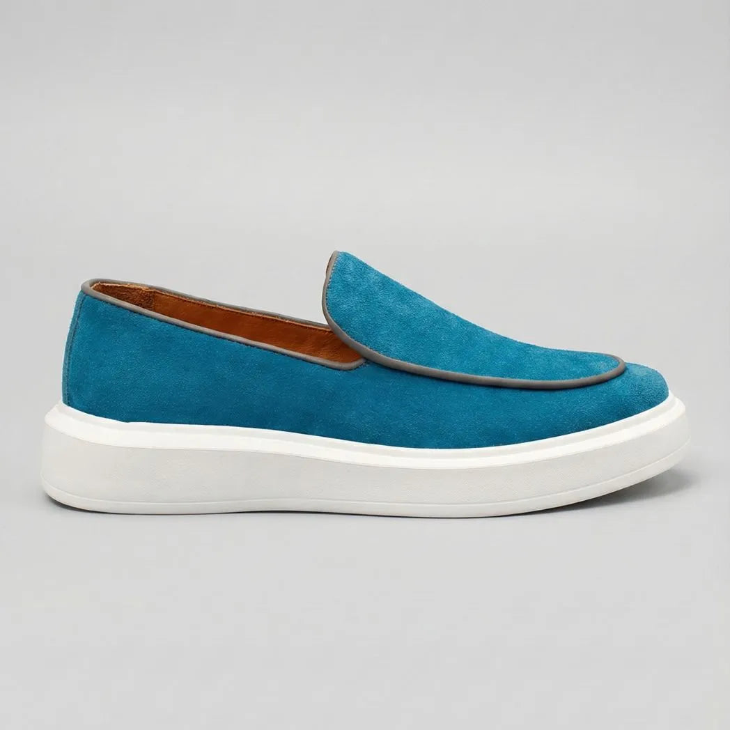 Mocassim Loafer de Camurça Vanguard: modelo azul de perfil, com contorno da parte frontal escuro e sola branca.