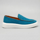 Mocassim Loafer de Camurça Vanguard: modelo azul de perfil, com contorno da parte frontal escuro e sola branca.
