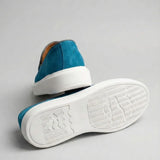 Mocassim Loafer de Camurça Vanguard: par azul com um sapato virado, mostrando a sola branca com relevo.