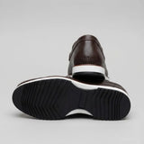 Mocassim Loafer de Couro Berlin Edição Limitada X-20: par marrom-escuro com um sapato virado, mostrando a sola preta com sulcos diagonais e detalhe branco.