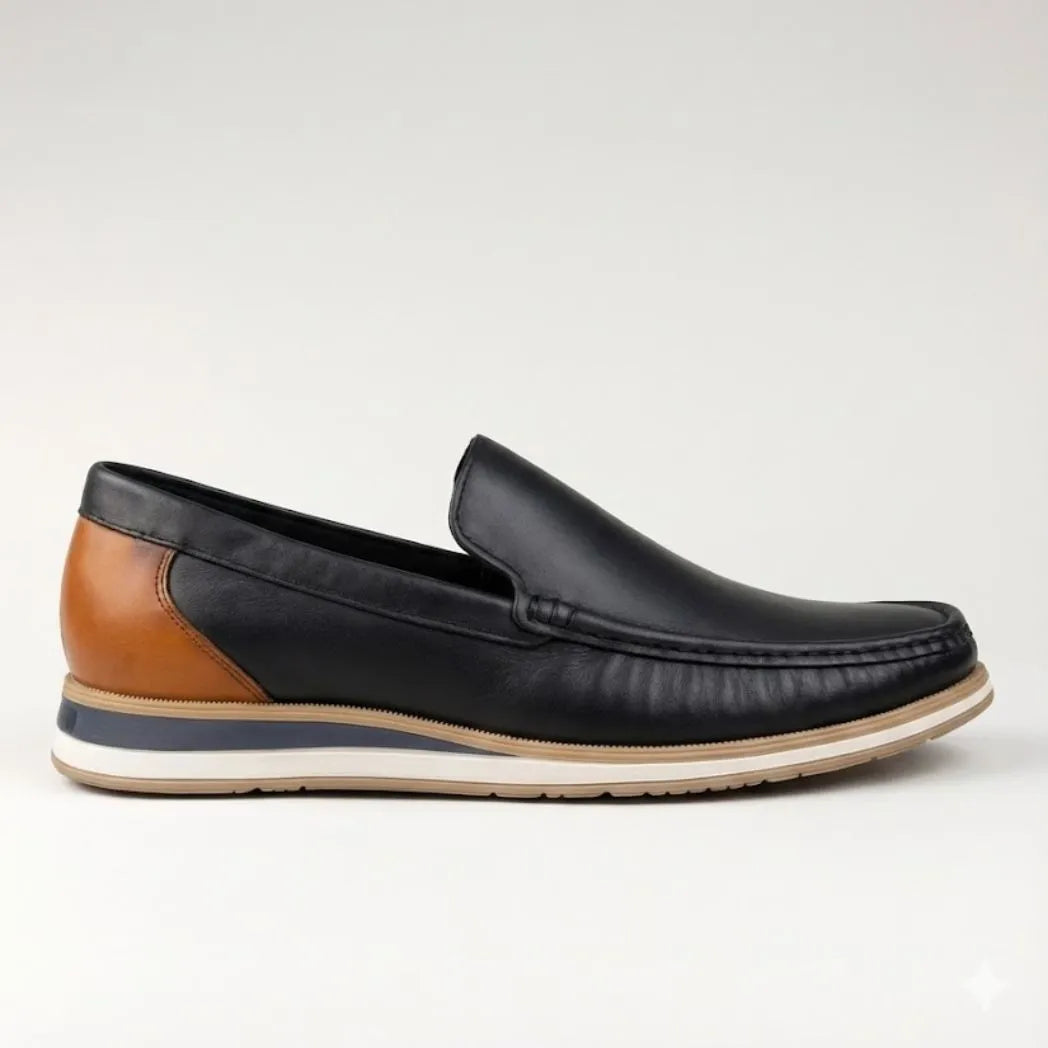Mocassim Loafer de Couro Contrast: modelo preto de perfil, com costura frontal, detalhe marrom na parte traseira e sola bege.