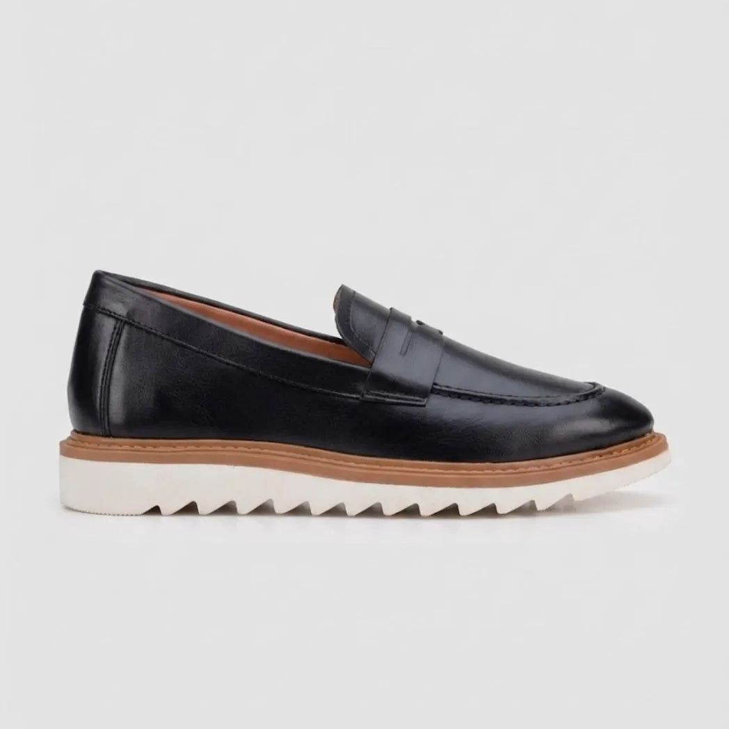 Mocassim Loafer de Couro Napoli: modelo preto de perfil, com faixa frontal, borda marrom e sola branca de sulcos profundos.