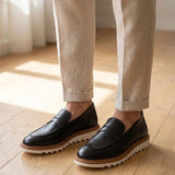 Mocassim Loafer de Couro Napoli: par preto com sola branca e borda marrom usado com calça clara dobrada na barra.
