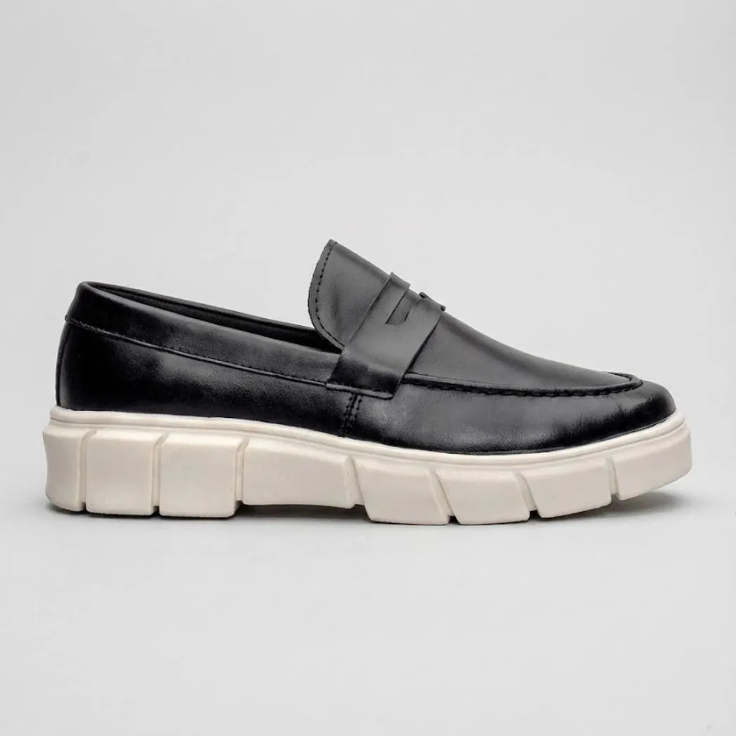 Mocassim Lunar Tratorado: modelo preto de perfil, com faixa frontal e sola clara espessa com sulcos largos.