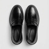 Mocassim Masculino Costurado Piettro: par preto visto de cima, mostrando a faixa frontal e o interior preto.