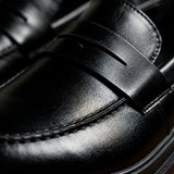 Detalhe da faixa penny sem fivela e das costuras do Mocassim Masculino Piettro Preto em couro.