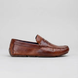 Mocassim Masculino Driver de Couro: modelo marrom de perfil, com faixa frontal e costura na parte frontal.