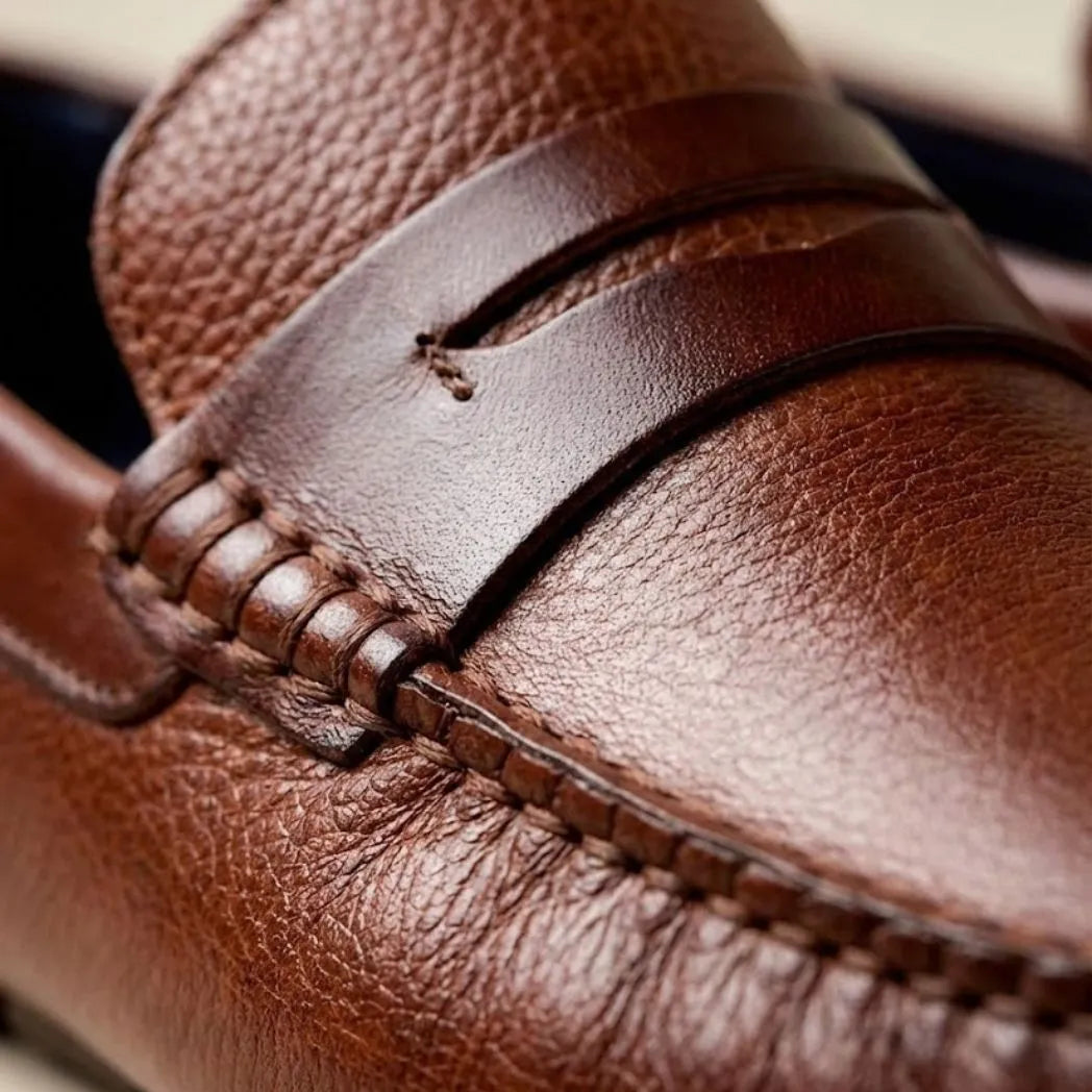 Mocassim Masculino Driver de Couro: detalhe da superfície marrom, da faixa frontal e da costura.