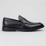 Mocassim Masculino Genova Loafer Couro: modelo preto de perfil, com faixa frontal e salto baixo preto.