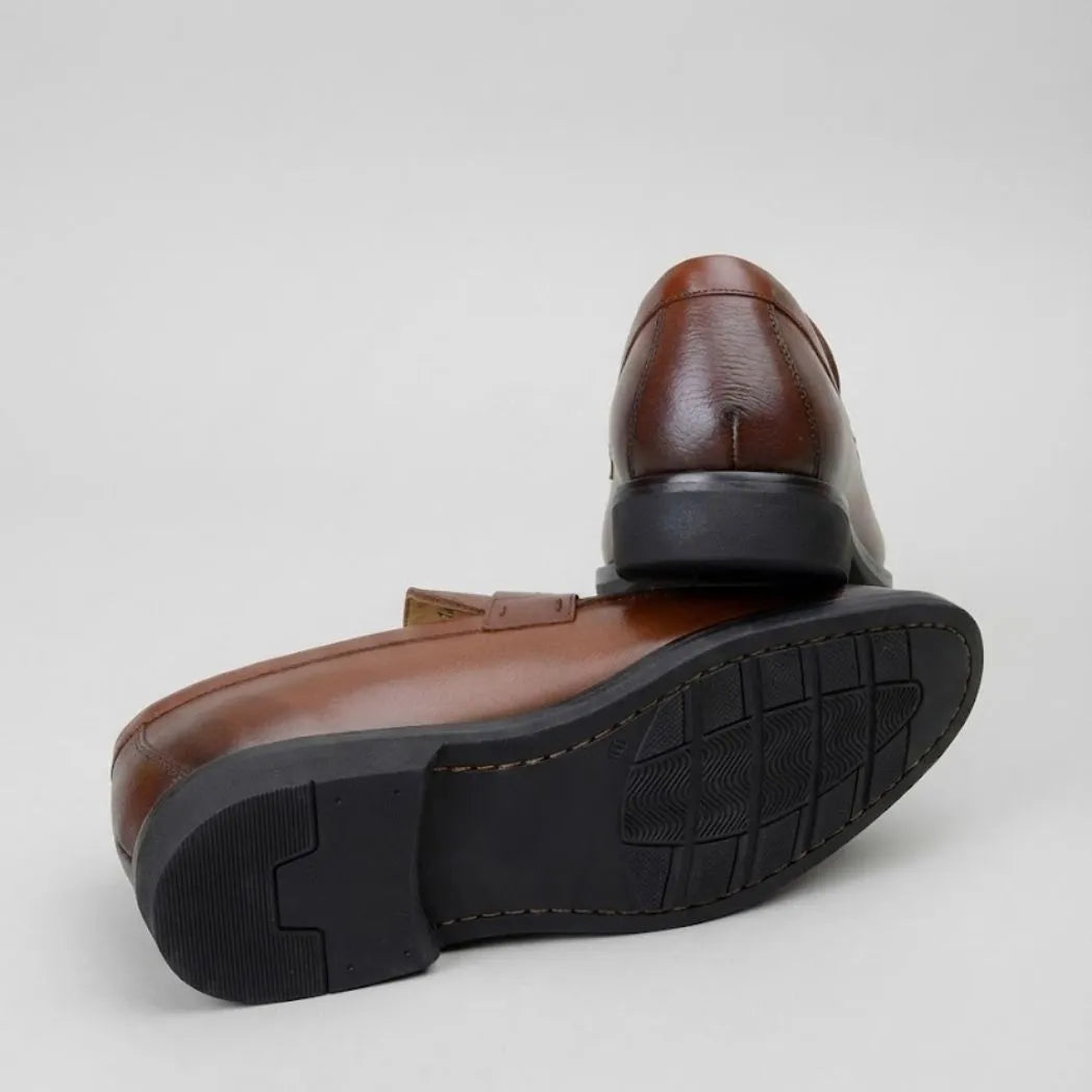 Mocassim Masculino Genova Loafer Couro: par marrom com um sapato virado, mostrando a sola preta com sulcos.