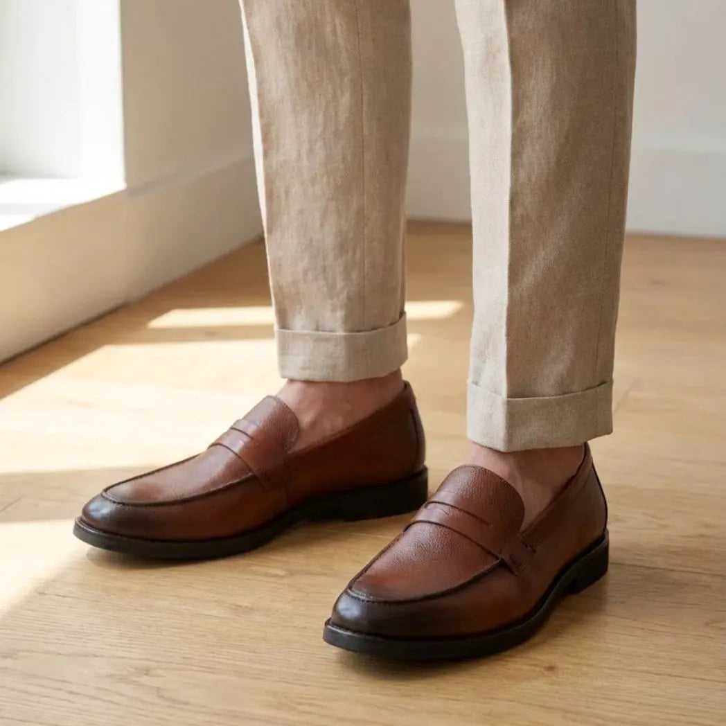 Mocassim Masculino Genova Loafer Couro: par marrom usado com calça clara dobrada na barra.
