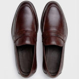 Mocassim Masculino Genova Loafer Couro: par marrom-escuro visto de cima, mostrando a faixa frontal e o interior escuro.