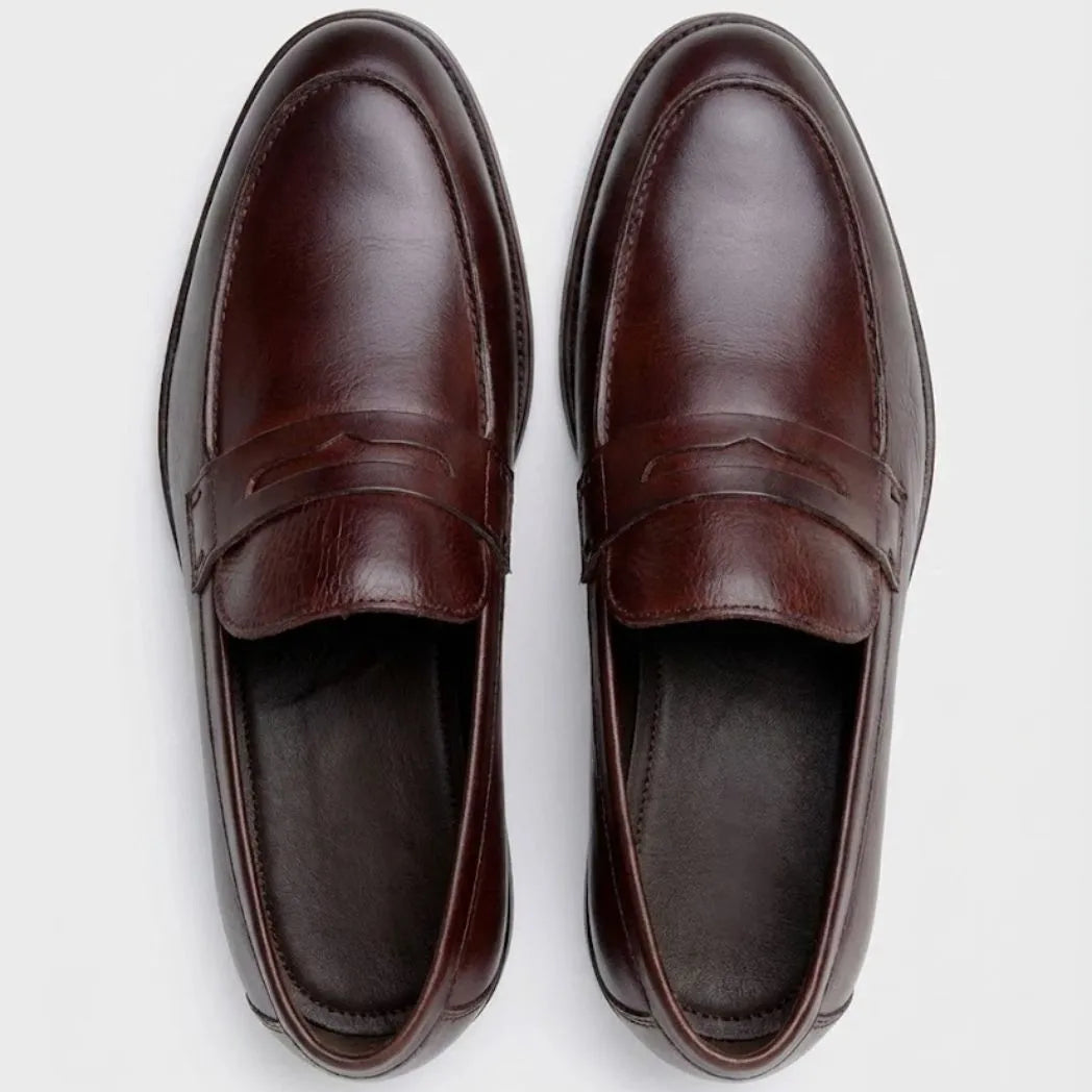 Mocassim Masculino Genova Loafer Couro: par marrom-escuro visto de cima, mostrando a faixa frontal e o interior escuro.