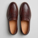 Mocassim Masculino Loafer Atenas: par marrom-escuro visto de cima, mostrando a faixa frontal e o interior marrom.