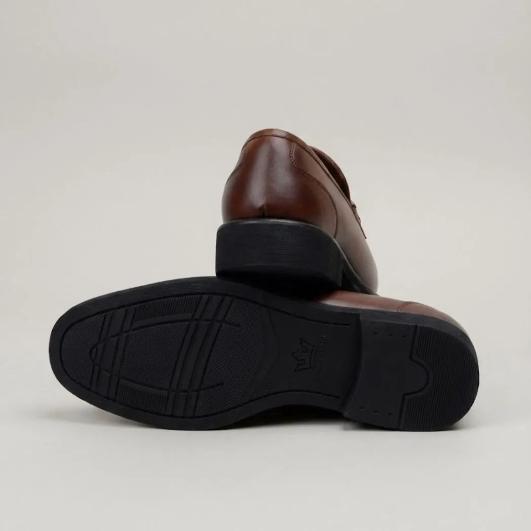 Mocassim Masculino Loafer Milan de Couro: par marrom com um sapato virado, mostrando a sola preta com sulcos.