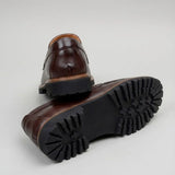 Mocassim Masculino Siena Loafer de Couro: par marrom-escuro com um sapato virado, mostrando a sola preta com sulcos profundos.