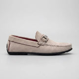 Mocassim Milano Driver com Fivela: modelo claro de perfil, com ferragem retangular prateada, costura frontal e sola preta.