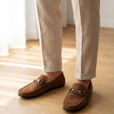 Mocassim Milano Driver com Fivela na cor marrom, usado com calça clara de barra dobrada.