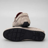 Par do modelo Mocassim Milano Driver com Fivela, na cor branco, com um dos solados voltado para a câmera.