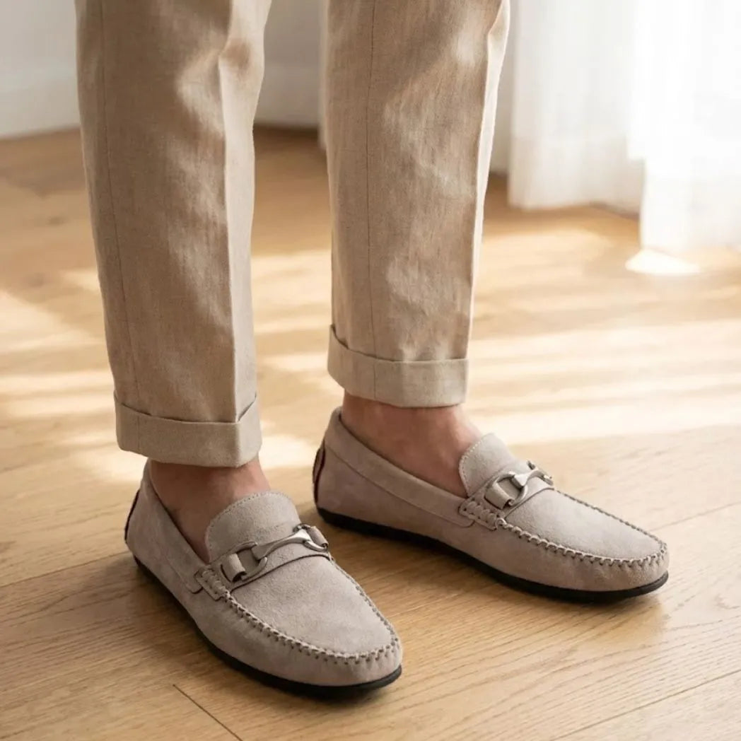 Mocassim Milano Driver com Fivela na cor branco, usado com calça clara de barra dobrada.