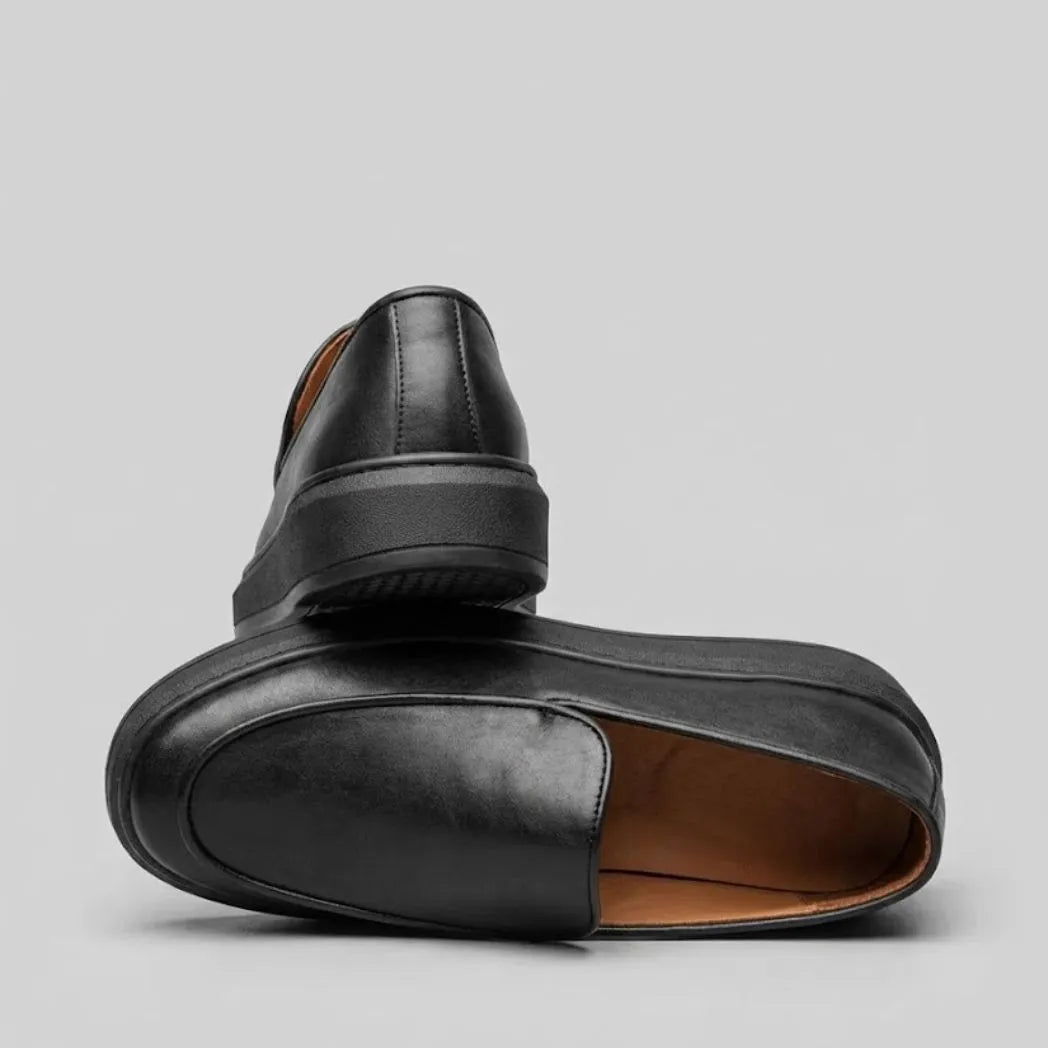 Mocassim Minimalista de Couro: par preto em posições opostas, mostrando a abertura e a parte traseira dos sapatos.