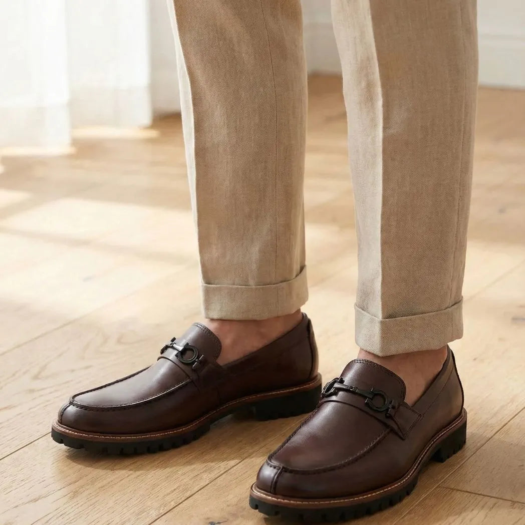 Mocassim Napoli com Fivela na cor marrom-escuro, usado com calça clara de barra dobrada.