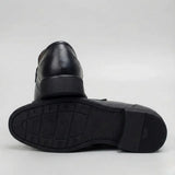 Par do modelo Mocassim Nero Rebel com Fivela, na cor preto, com um dos solados voltado para a câmera.