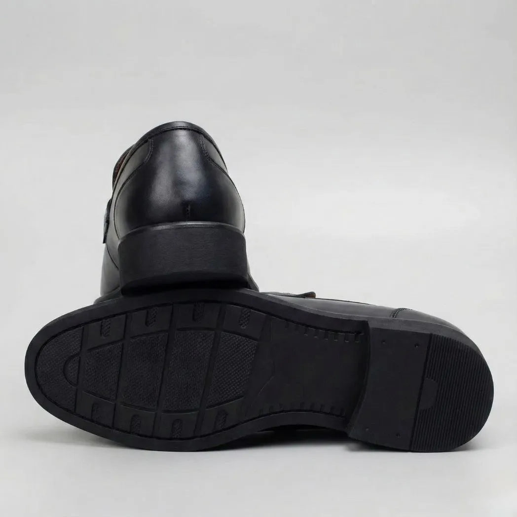 Par do modelo Mocassim Nero Rebel com Fivela, na cor preto, com um dos solados voltado para a câmera.