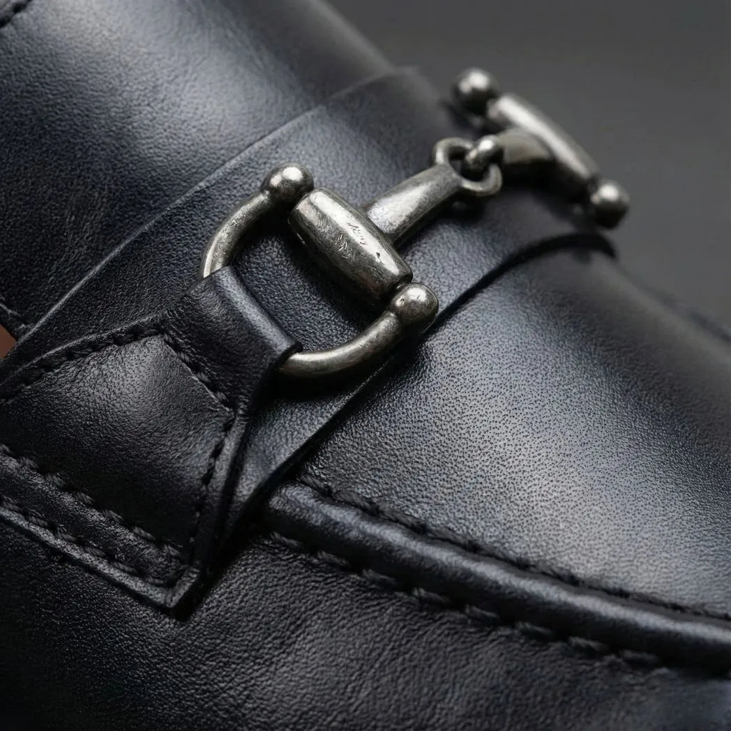 Detalhe da fivela metálica, da textura e das costuras do Mocassim Nero Rebel com Fivela na cor preto.