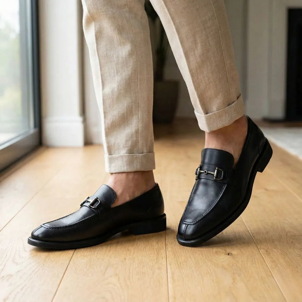 Mocassim Nero Rebel com Fivela na cor preto, usado com calça clara de barra dobrada.