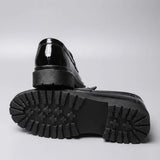 Par do modelo Mocassim Obsidian de Couro, na cor preto, com um dos solados voltado para a câmera.