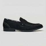 Mocassim Penny Loafer Milano Cognac: modelo preto de perfil, com faixa frontal, costura clara e sola preta.