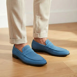 Mocassim Penny Loafer Milano Cognac: par azul usado com calça clara dobrada na barra.