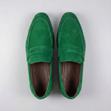 Mocassim Penny Loafer Milano Cognac: par verde visto de cima, mostrando faixa frontal e interior escuro.