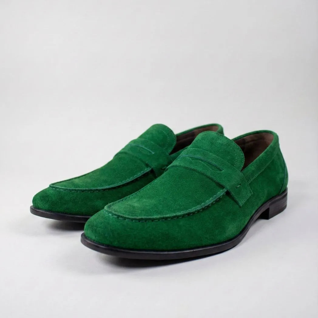 Mocassim Penny Loafer Milano Cognac: par verde em vista diagonal, com faixa frontal e sola preta.